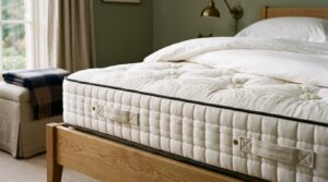Editorial close-up of a premium pocket-sprung mattress with hand-stitched trim and quilted surface